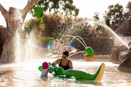 a woman is playing in a water park at ZEcamping 4 étoiles avec chiens acceptés piscine chauffée à 1km de la plage in Torreilles