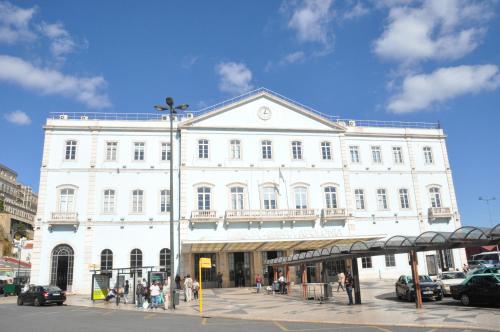 a large white building with people standing outside of it at Place Polonia in Lisbon