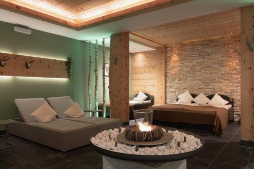 a living room with a couch and a bed at Verwöhnhotel Wildspitze in Sankt Leonhard im Pitztal