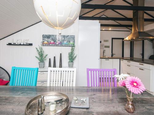 a kitchen with a table with a vase with a pink flower at 4 person holiday home in Toftlund in Toftlund