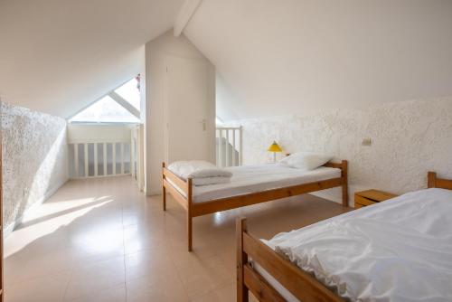a bedroom with two beds and a balcony at CAMPING LE SAILLET Lestelle Betharram in Lestelle-Bétharram