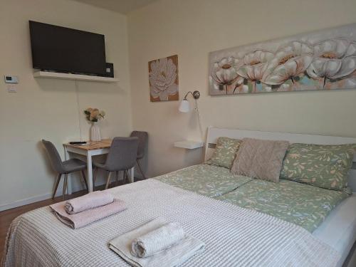 a bedroom with a bed with two towels on it at Emma Apartman 2 in Vecsés