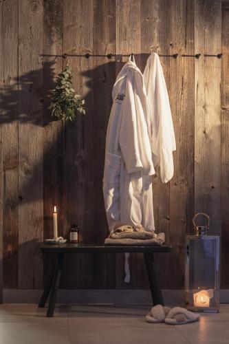 a robe hanging on a wooden wall with a candle at Verwöhnhotel Wildspitze in Sankt Leonhard im Pitztal