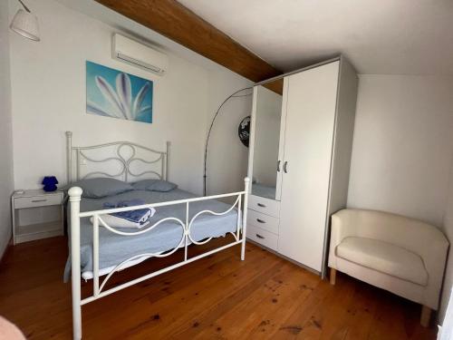 una piccola camera da letto con un letto e una sedia di Location Luccini a Saintes-Maries-de-la-Mer