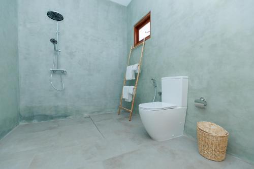 a bathroom with a shower and a toilet and a window at KIRI's HEAVEN in Ahangama