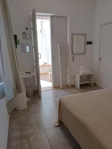 a bedroom with a bed and a bathroom with a toilet at Sottovento Marzamemi Rooms&Relax in Marzamemi