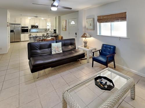 a living room with a black leather couch and a table at Paradise Retreat in Port Aransas
