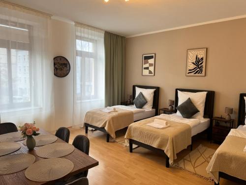 a hotel room with two beds and a table at Arminos Large Group Apartment- 3 Zimmer & 2 WCs in Chemnitz