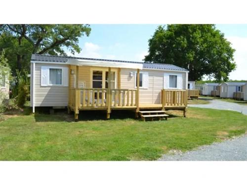 a yellow caravan with a porch and a deck at Chalet 4 étoiles - Piscine - ef0c00 in Monceaux-sur-Dordogne