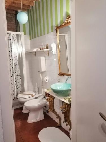 a bathroom with a sink and a toilet and a mirror at Corte di Maggio B&B in Imola