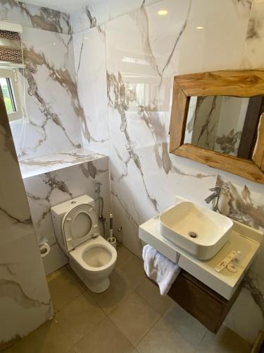 a bathroom with a toilet and a sink at Presken Hotel White House, Lekki, Lagos in Lagos