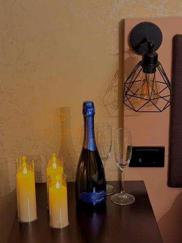 Eine Flasche Wein und zwei Kerzen auf einem Tisch in der Unterkunft Hotel NIRÁ in Sofia