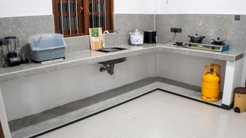 a kitchen with a counter with a yellow appliance on it at Golden Breeze Mirissa in Kamburugamuwa