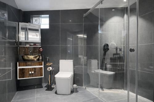 a bathroom with a toilet and a glass shower at Hotel Materhorn in Kovalam