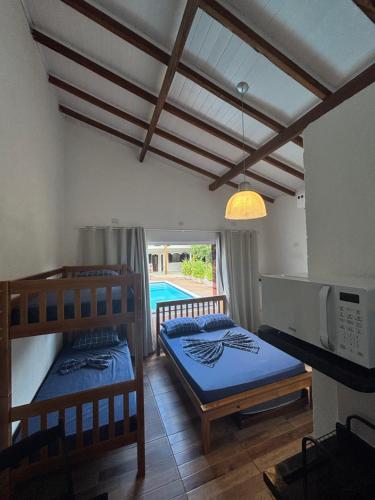 a bedroom with two bunk beds and a pool at Pousada da Árvore in Boicucanga