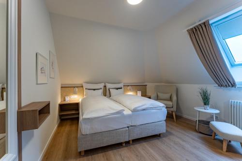 a bedroom with a bed and a desk and a window at Wellings Romantik Hotel zur Linde in Moers