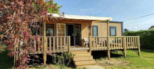 a tiny house with a porch and stairs at ZEcamping 3 étoiles animaux acceptés sauna piscine couverte in Mont-près-Chambord