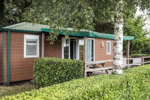 a small cabin with a picnic table and a green roof at Camping 3 étoiles - ccaidff in Beaulieu
