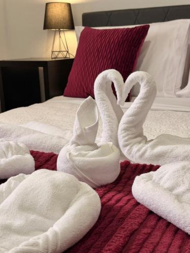 two swans shaped like hearts sitting on a bed at Ocean View Guest House in São Vicente