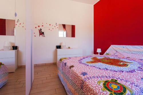 una camera con letto e parete rossa di Villa senza pensieri a Castel Volturno