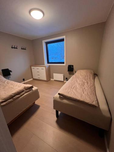 a bedroom with two beds and a window at Sentral toppleilighet 3.etg 4 pers in Svolvær
