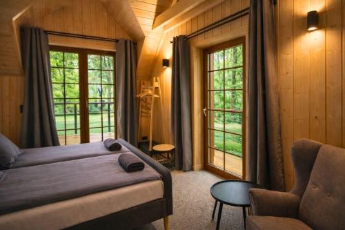a bedroom with a bed and a couch and windows at Leśna Przystań apartamenty dwupoziomowe nad jeziorem in Węgorzewo