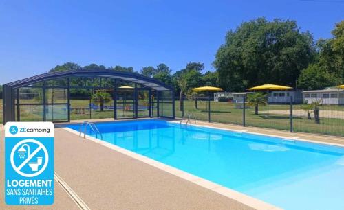 a swimming pool at a resort with a sign next to it at ZEcamping 3 dog friendly salle fitness piscine in Vensac