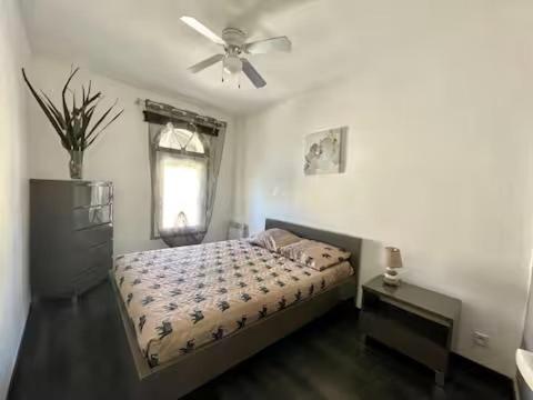 a bedroom with a bed and a ceiling fan at Le VILLAJOUN in Saintes-Maries-de-la-Mer