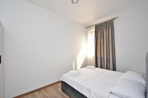 a bedroom with a white bed and a window at Riposo Hotel Armenia in Pʼarakʼar