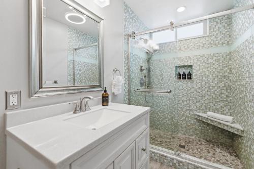 a white bathroom with a sink and a shower at Stunning Beach Home - large patio, parking, ac & dog friendly! in San Diego