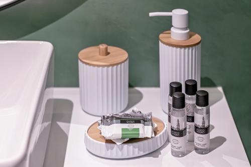 a bathroom with a sink and some products on a table at Land Roots Riverside Apartments in Vila Nova de Gaia