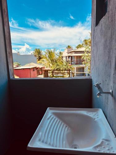 a sink in a window with a view of a city at Flats Coco Coral in Barra Grande