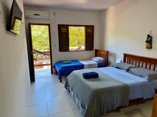 a bedroom with two beds and a balcony at Flats Coco Coral in Barra Grande