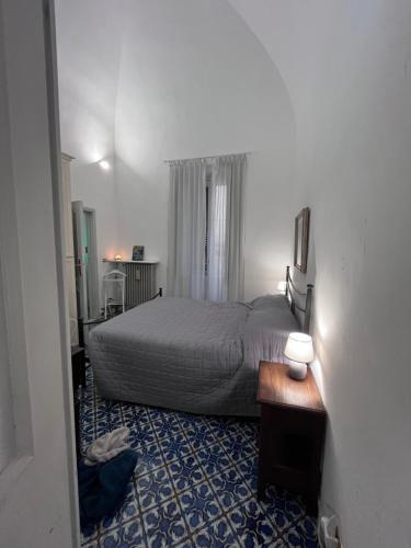a bedroom with a bed and a table with a lamp at Suite LA BARONESSA in Lecce