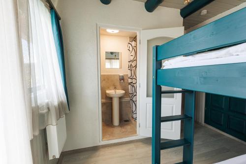 a bedroom with a bunk bed and a bathroom at Cabana Vitus Panzió in Harghita-Băi