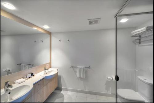 a bathroom with a sink and a toilet and a shower at River's Edge Premium Retreat in Ballina