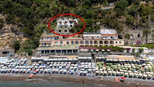 a large building on a beach with a red circle at La Dolce Vita a Positano boutique hotel in Positano