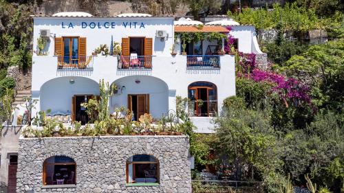 a white building with plants on top of it at La Dolce Vita a Positano boutique hotel in Positano