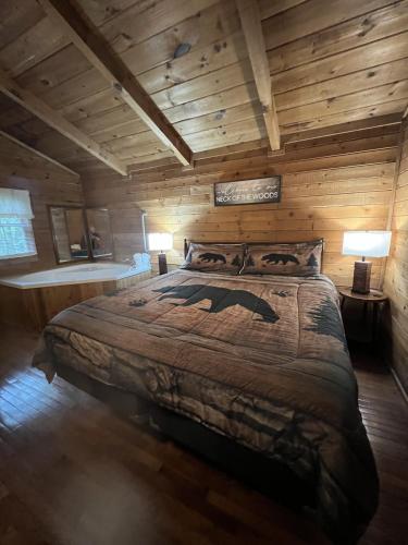 a bedroom with a large bed in a log cabin at Bavarian Hideaway 46 in Sautee Nacoochee