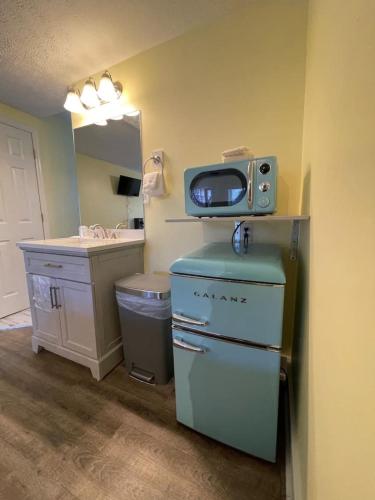a bathroom with a sink and a microwave on top of a refrigerator at Bavarian Brook Unit 3 in Helen