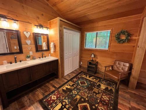 a bathroom with a tub and a sink and a chair at Bavarian Hideaway 25 in Helen
