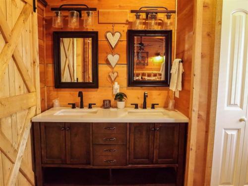 a bathroom with a sink and two mirrors at Bavarian Hideaway 25 in Helen