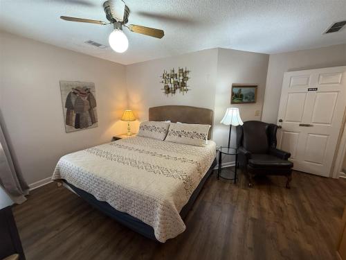 a bedroom with a bed and a ceiling fan and a chair at Rivers Edge 803A in Helen