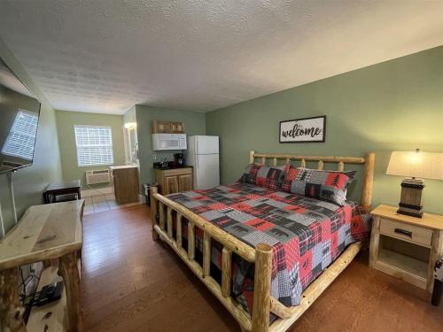 a bedroom with a wooden bed and a kitchen at Bavarian Brook Unit 7 in Helen