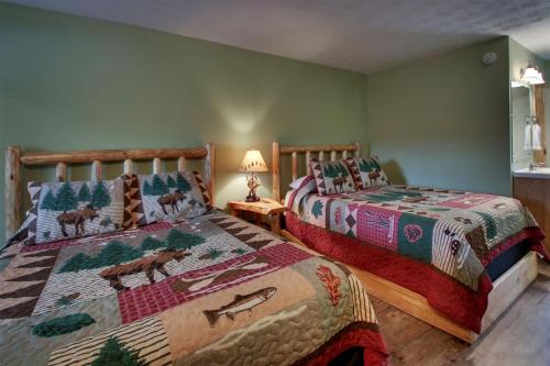 two beds in a bedroom with green walls at Bavarian Brook 8a in Helen
