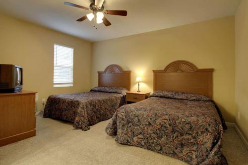 a bedroom with two beds and a ceiling fan at Bavarian Brook Condo 11 in Helen