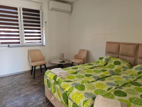 a bedroom with a bed and two chairs and a window at Smeštaj kod Lazarice Šid in Šid