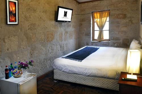 Un dormitorio con una cama grande y una ventana en Hoteles Riviera Colonial, en Arequipa