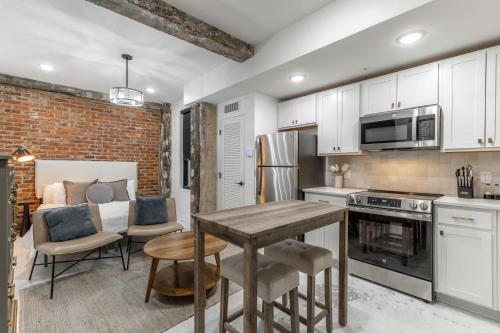 a kitchen with white cabinets and a table with chairs at Park Hotel Studio Suite 303 in Chattanooga