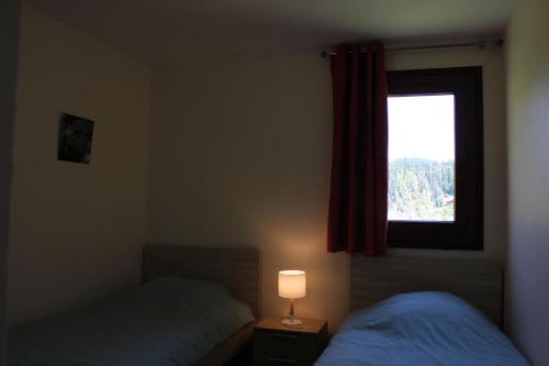 een slaapkamer met twee bedden en een raam bij Les faons in Roubion